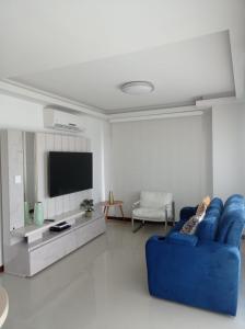 ein Wohnzimmer mit einem blauen Sofa und einem TV in der Unterkunft Luxury apartment, sector morros, vista y salida al mar edificio Sunshine in Cartagena de Indias