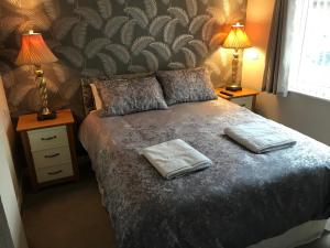 a bedroom with a bed with two towels on it at Rannoch Lodge in Auchterarder