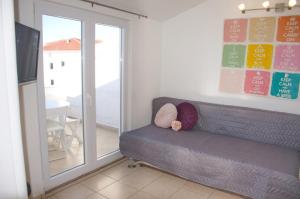 a living room with a couch and a sliding glass door at Apartments Summer Joy in Novalja