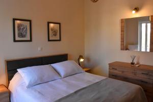um quarto com uma cama, uma cómoda e um espelho em Apartment in Peania em Paianía