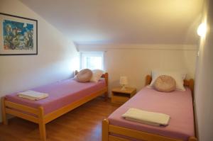 two twin beds in a room with a window at Apartments Summer Joy in Novalja