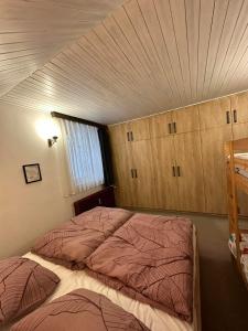 - une chambre avec un grand lit et un plafond dans l'établissement Apartma Marni, à Kranjska Gora