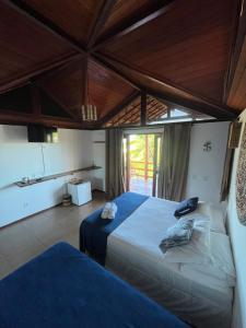a bedroom with two beds and a large window at Pousada Lá em Casa in Barra Grande