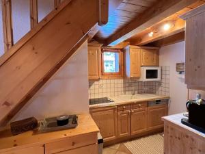 uma cozinha com armários de madeira e uma escada em Appartement Méribel, 4 pièces, 6 personnes - FR-1-688-49 em Méribel