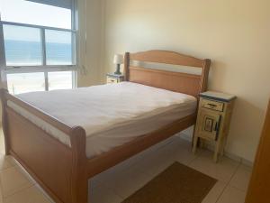 a bedroom with a bed and a window with the ocean at Apartamento Centro Frente Mar-Mongaguá in Mongaguá