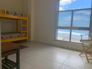 a room with a bedroom with a bunk bed and a window at Apartamento Centro Frente Mar-Mongaguá in Mongaguá