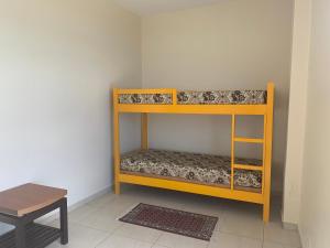 a bunk bed in a room with a table at Apartamento Centro Frente Mar-Mongaguá in Mongaguá