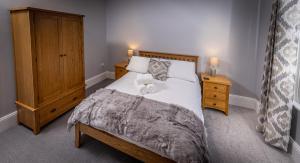 a bedroom with a bed and a dresser with two towels at Spacious 1st Floor Apartment in Keswick