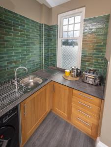 a small kitchen with a sink and a window at Spacious 1st Floor Apartment in Keswick