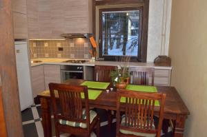 a kitchen with a wooden table with four chairs and a kitchen sidx sidx at Villa San in Zlatibor