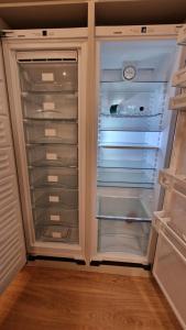 um frigorífico vazio com a porta aberta numa cozinha em MESHI APARTMENT em Durrës