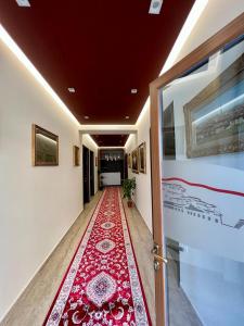 um corredor com um tapete vermelho no chão em Hotel Vila Mimani em Berati