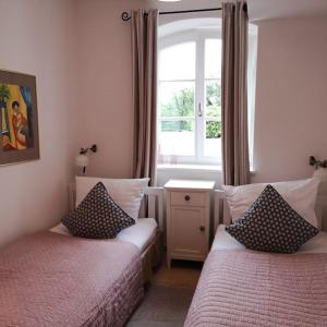 1 dormitorio con 2 camas y ventana en Ferienwohnung Gutshof in Seenähe en Dießen am Ammersee