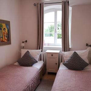 1 Schlafzimmer mit 2 Betten und einem Fenster in der Unterkunft Ferienwohnung Gutshof in Seenähe in Dießen am Ammersee