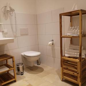 ein weißes Bad mit einem WC und einem Waschbecken in der Unterkunft Ferienwohnung Gutshof in Seenähe in Dießen am Ammersee