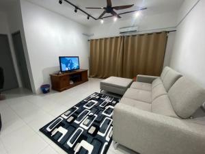 ein Wohnzimmer mit einem Sofa und einem Flachbild-TV in der Unterkunft residensi condominium, taman melati, danau kota, gombak in Kuala Lumpur