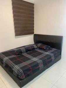 Schlafzimmer mit einem Bett mit schwarzem Kopfteil in der Unterkunft residensi condominium, taman melati, danau kota, gombak in Kuala Lumpur