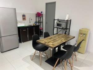 eine Küche mit einem Holztisch und schwarzen Stühlen in der Unterkunft residensi condominium, taman melati, danau kota, gombak in Kuala Lumpur