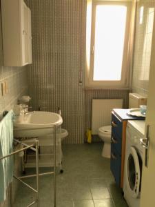 a bathroom with a sink and a toilet and a window at Udine Urban Stay in Udine