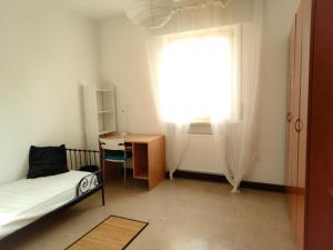 una camera con letto, scrivania e finestra di Udine Urban Stay a Udine