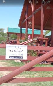 ein Schild auf einem Zaun vor einem Gebäude in der Unterkunft Cabaña La Justina in San José