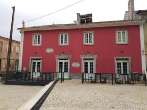 un edificio rosso in mezzo a una strada di Penaferrim Sintra Rooms a Sintra