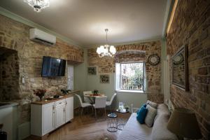 ein Wohnzimmer mit einem Sofa und eine Küche mit einem Tisch in der Unterkunft Bruskos luxury in Korfu-Stadt
