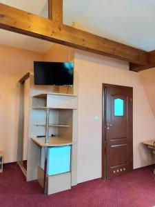 Habitación con cama elevada y TV de pantalla plana. en Motel Delfin ** en Trojanów