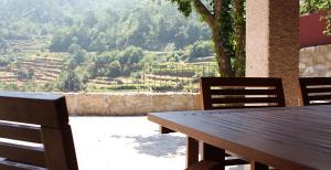 a wooden table and chairs with a view of a valley at Casa da Avó in Arcos de Valdevez