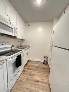 eine Küche mit weißen Schränken und einem weißen Kühlschrank in der Unterkunft Cozy 1 bedroom Apartment in Downtown Gadsden, AL in Gadsden