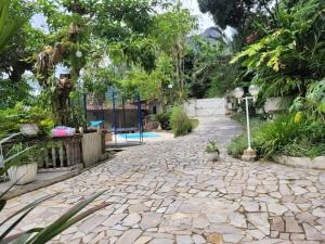 una pasarela de piedra en un jardín con árboles en Linda casa no Rio de Janeiro (Itanhangá), en Río de Janeiro