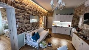 ein Wohnzimmer mit Ziegelwand und eine Küche in der Unterkunft Bruskos luxury in Korfu-Stadt