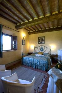 1 dormitorio con 1 cama, mesa y sillas en Agriturismo Il Macchione, en Pienza