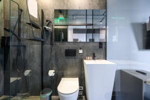 a bathroom with a shower and a toilet and a sink at Rich Sopot by OneApartments in Sopot