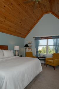 a bedroom with a large bed and two chairs at The Bradley Inn in New Harbor