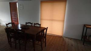 - une salle à manger avec une table et des chaises en bois dans l'établissement Runa, Marcos de los Reyes villa serrana, à Minas