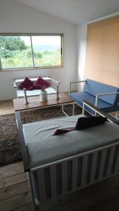 Zimmer mit 2 Betten, einem Tisch und einem Fenster in der Unterkunft Runa, Marcos de los Reyes villa serrana in Minas