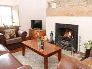 SmeafieldにあるKits Cottageのリビングルーム(暖炉、木製コーヒーテーブル付)