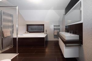 een badkamer met een bad, 2 wastafels en een douche bij Farma František in Stachy