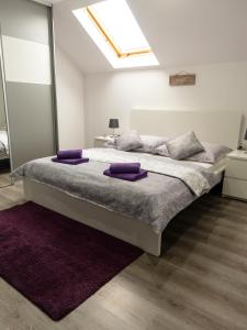 a bedroom with a large bed with purple pillows on it at Privat Nisa in Nová Lesná