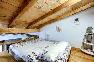 Bett in einem Zimmer mit Holzdecke in der Unterkunft El Capricho de Brihuega in Brihuega