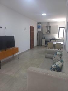 sala de estar con sofá y TV en Departamento Moreno Park Bloque 16 en Luján de Cuyo