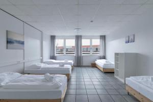 a room with three beds and a window at T&K Apartments - 3 - 5 Group Room Apartments- 15min to Fair DUS in Neuss