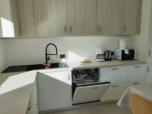 a white kitchen with a sink and a microwave at Paragole in Pera