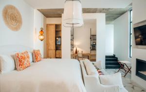 1 dormitorio con cama blanca y sofá en LOtel-Casa Arca en San Miguel de Allende