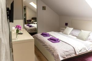 Un dormitorio con una cama con toallas moradas. en Privat Nisa, en Nová Lesná