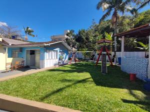 um quintal com um parque infantil numa casa em DK3 - CaSA COM 3 SUITES COM PISCINA BRUNO KLEMTZ em Itapema