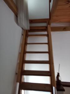 Una escalera de madera en una habitación con techo en Lo de Normi en Tandil