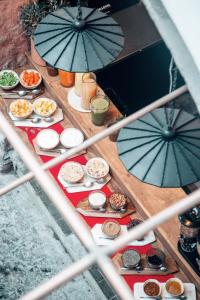 una mesa llena de comida con sombrillas. en LOtel-Casa Arca en San Miguel de Allende