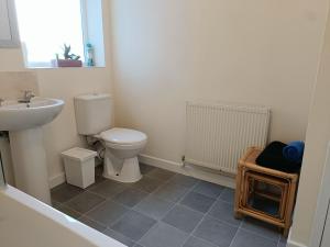 a bathroom with a white toilet and a sink at Bright, Comfortable Home, Convenient for City Centre in Liverpool